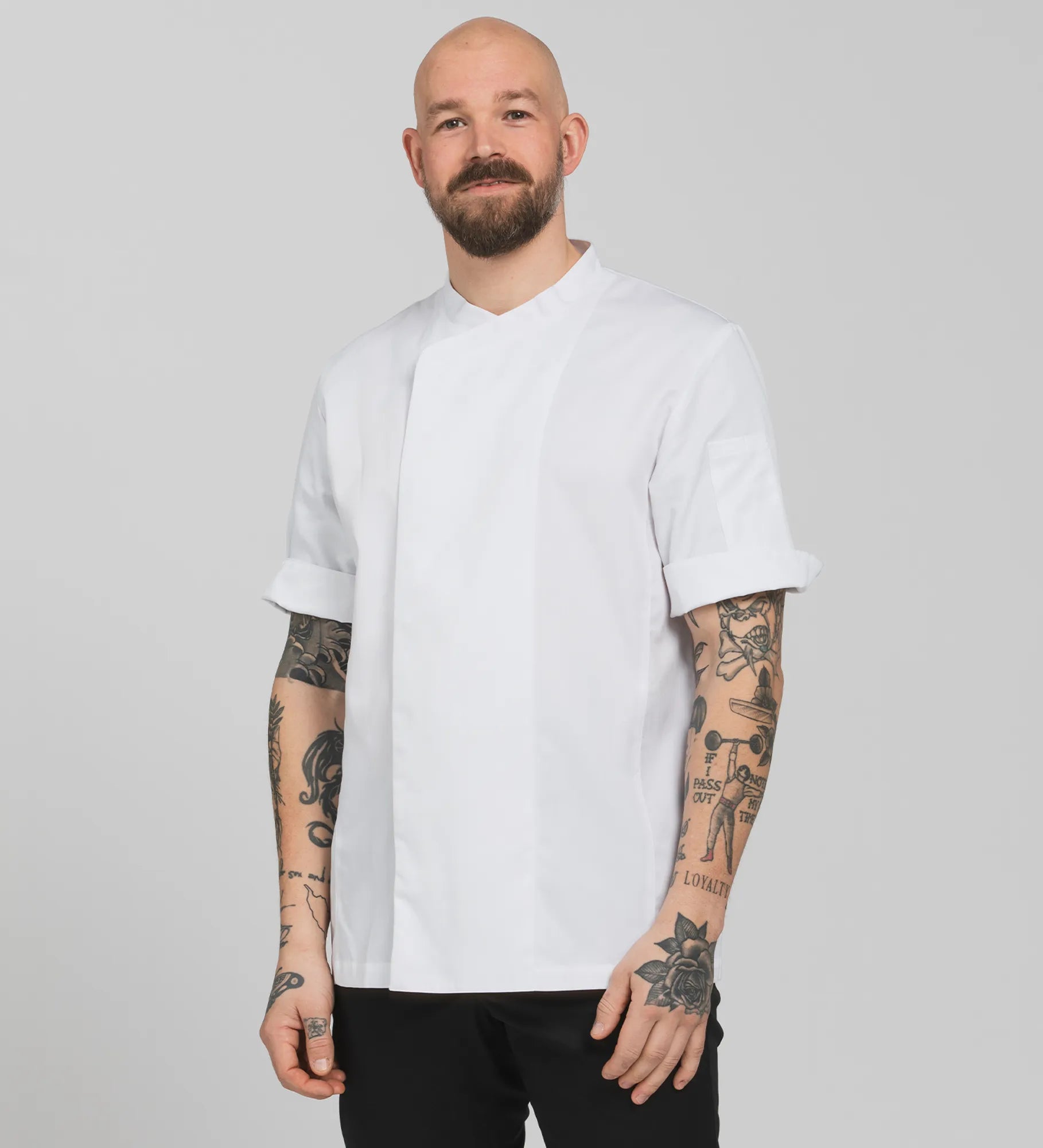 A man wearing a white unisex chef's jacket with short sleeves
