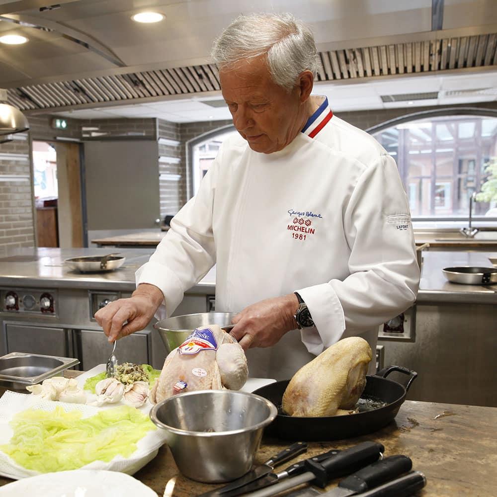Man wearing a white Lafont long sleeve chef's coat in an award winning kitchen