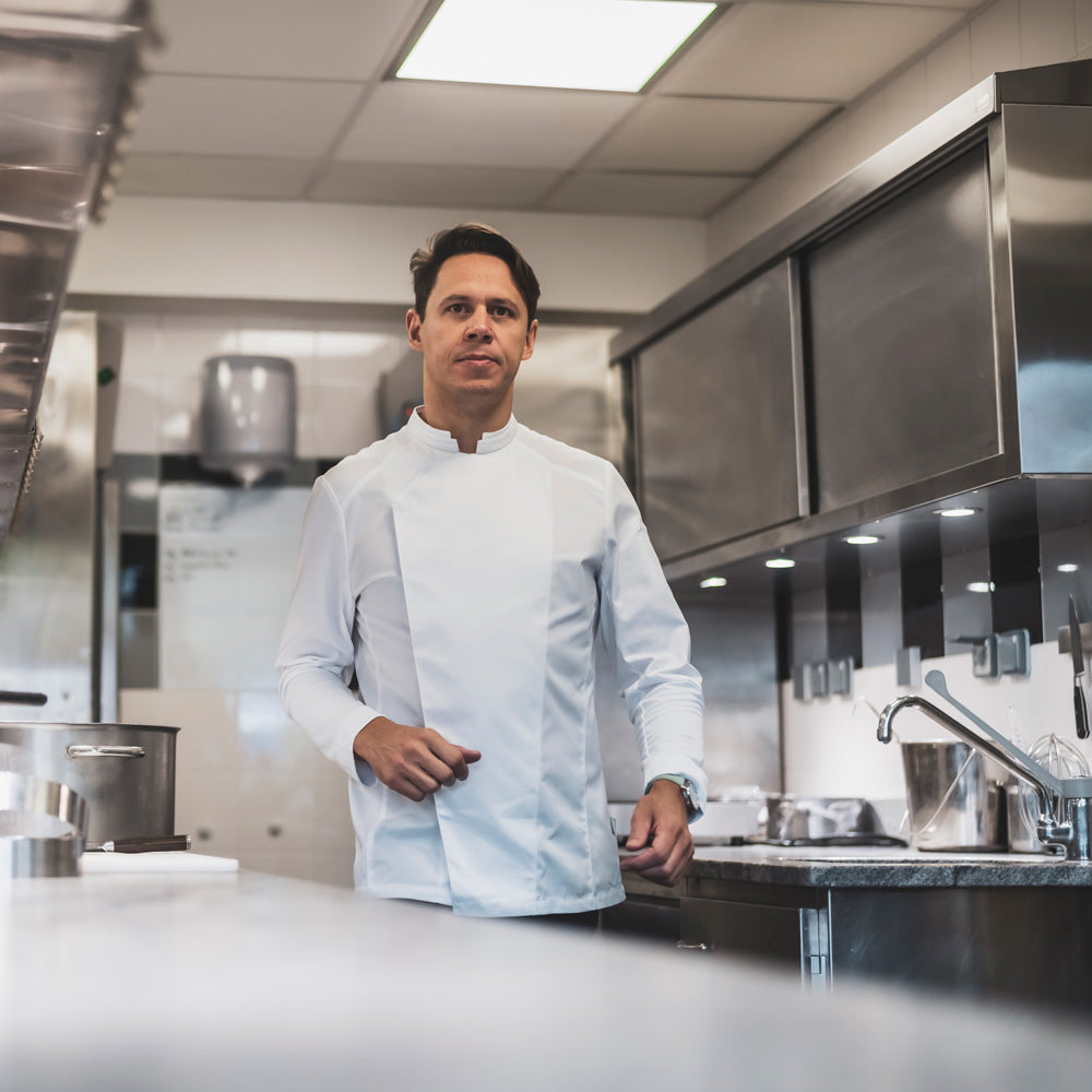 Michelin rated chef working in the kitchen in a long, sleeved, white double breasted, symmetrical chef c