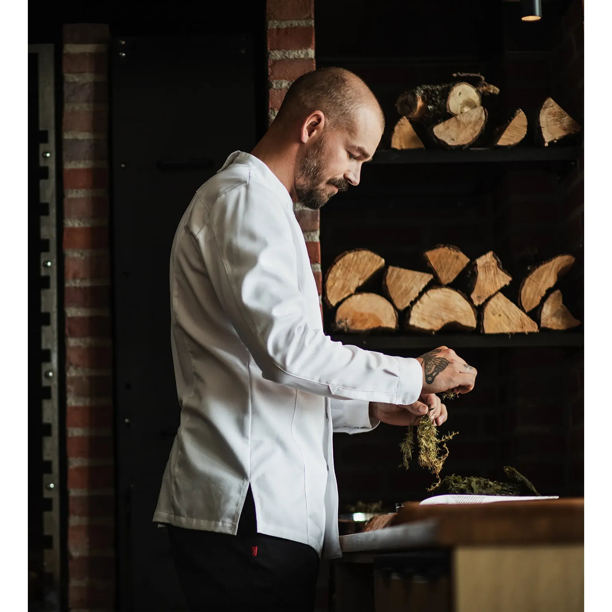Restraint Chef prepping in a long sleeve white chef jacket