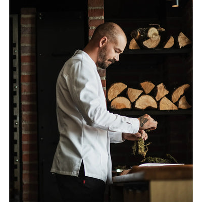 Restraint Chef prepping in a long sleeve white chef jacket