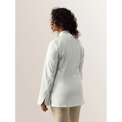 Woman wearing a premium light gray chef jacket against a plain background