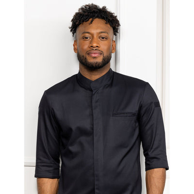 Man wearing a black long-sleeve chef coat with closed collar against a white background