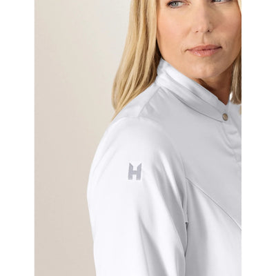 Person wearing a white high-neck chef coat with an H brand logo on the shoulder