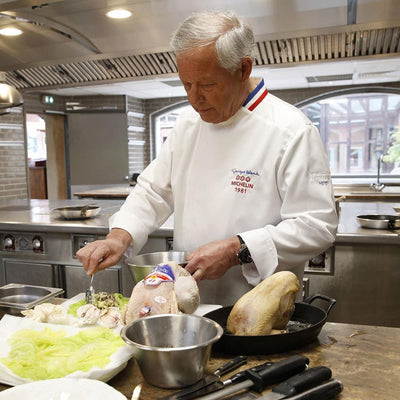 Man wearing a white Lafont long sleeve chef's coat in an award winning kitchen
