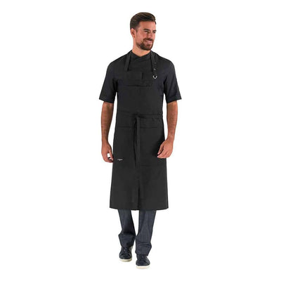 A restaurant waiter wearing a black bib apron with adjustable neck strap and ties, a bib pocket, and a large twin-compartment pocket on the chest.