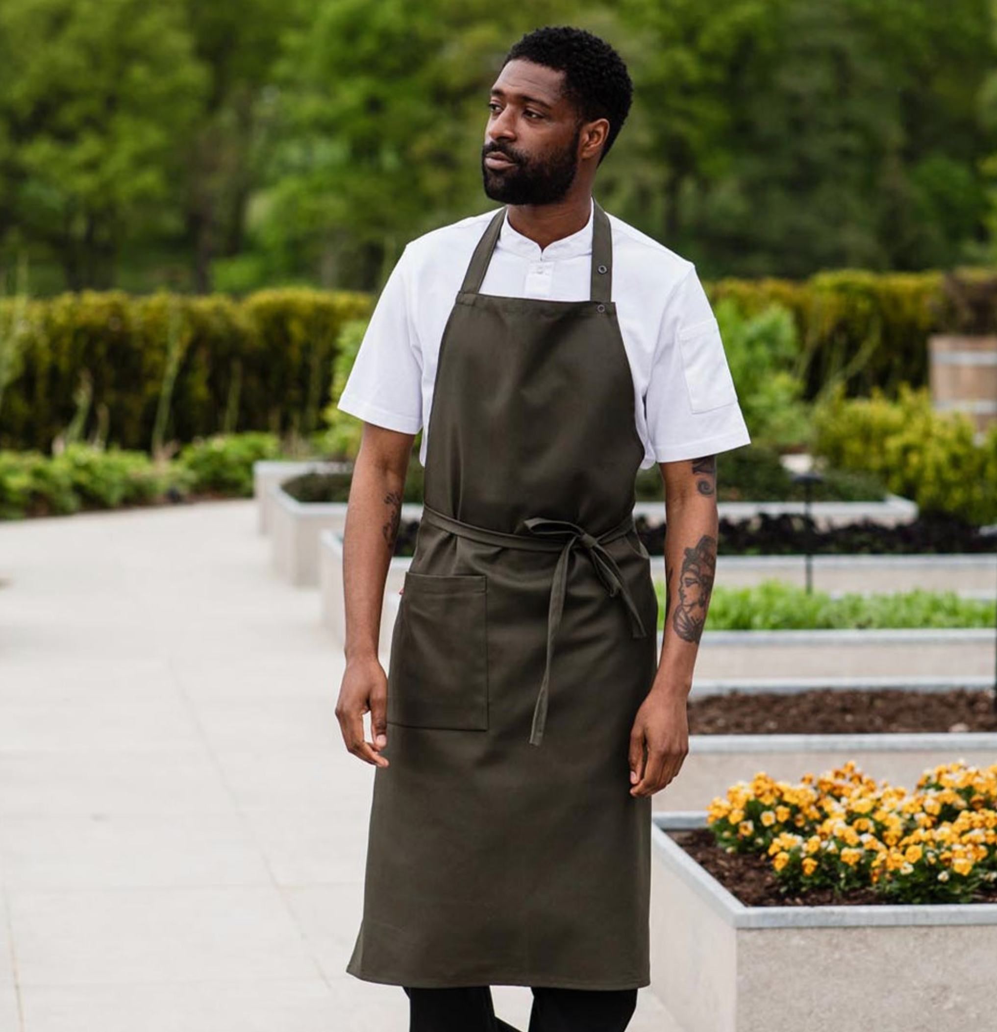 Executive chef, picking fresh ingredients in a bib apron
