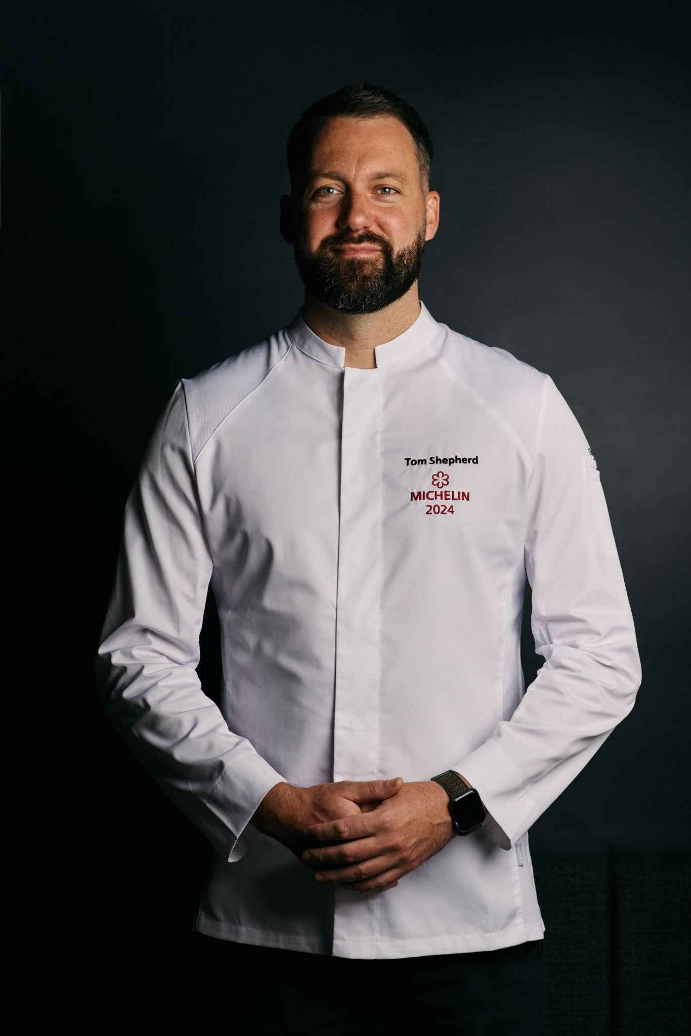 Michelin star chef standing in a long sleeve, white chef coat with hidden snaps and officer collar